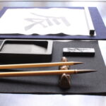 A photo of the calligraphy tools and the character for dragon, the zodiac sign of the year.