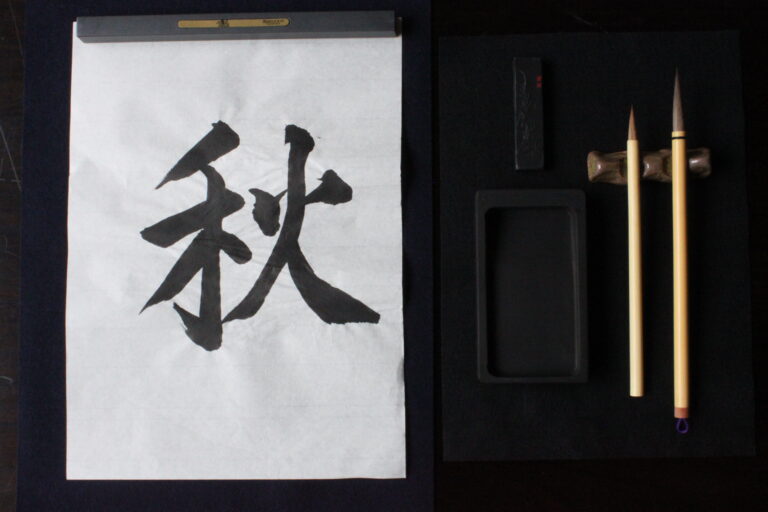 A photo of calligraphy tools and the character "autumn".