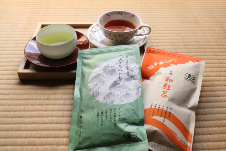 A photo of the tea packages, a cup of green tea, and a cup of black tea.