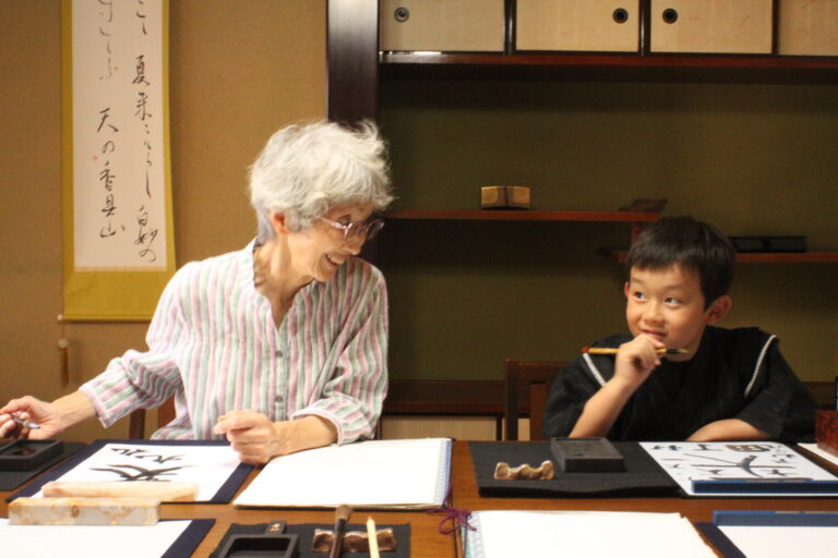 A photo of the participants enjoying calligraphy. One of them is an elder calligrapher.