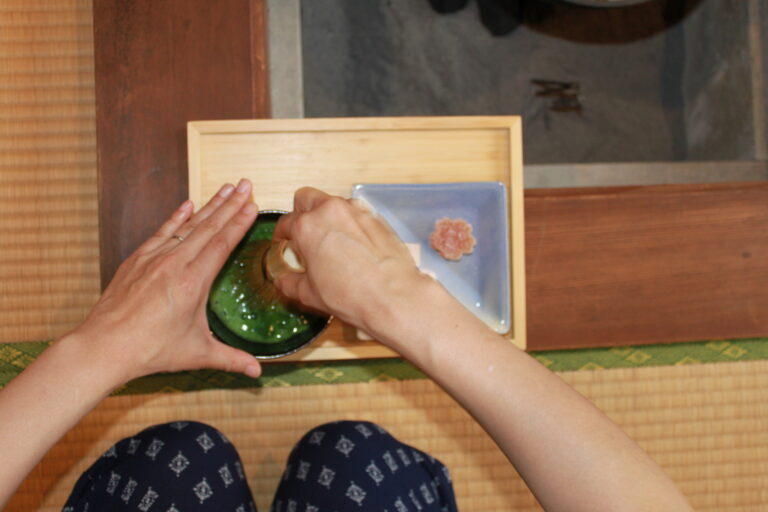 A photo of one of the guests is making her own matcha with a bamboo whisk.