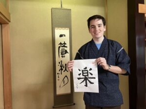 A photo of the guest, who is holding a calligraphy piece in his hand.