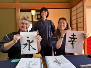 A photo of a guide and the participants, along with their own calligraphy works.