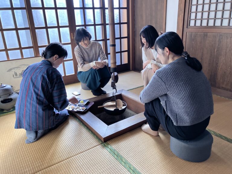 A photo of guests and a host around the irori.