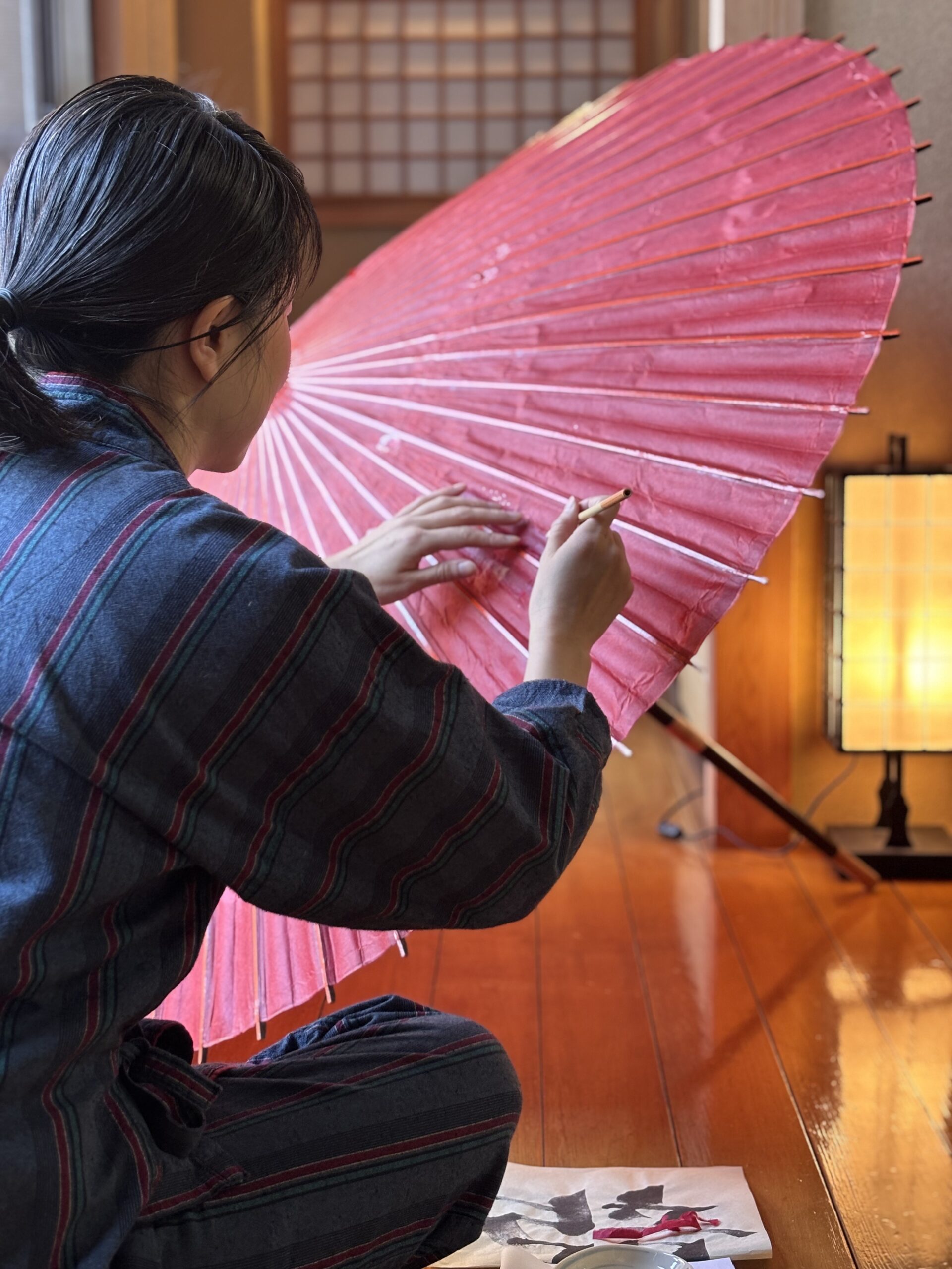 A photo of the shop manager repairing a Japanese umbrella.