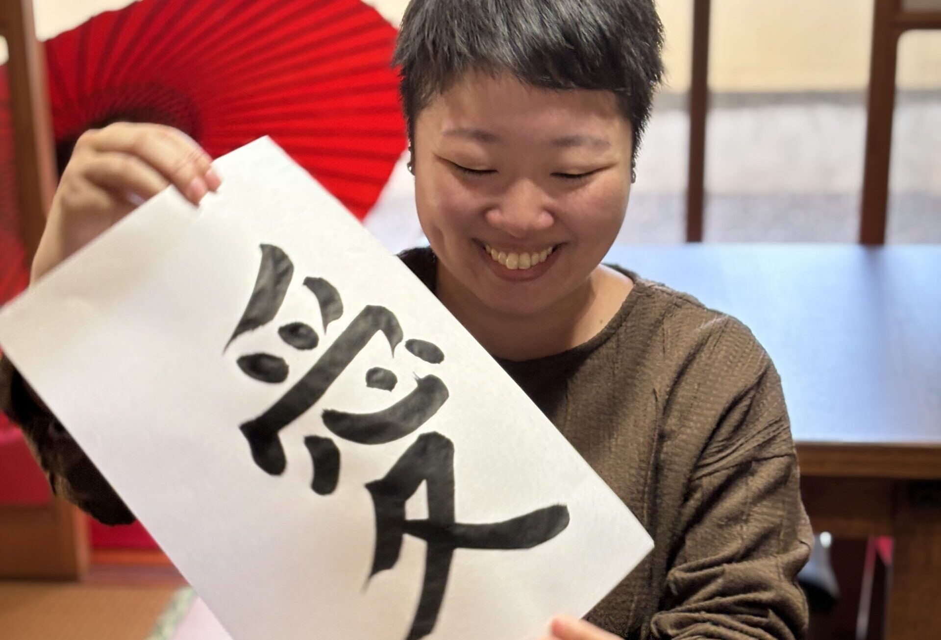 A photo of a guest and her calligraphy piece.