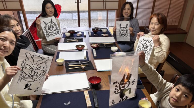 A photo of our guests showing their oni or demon paintings.