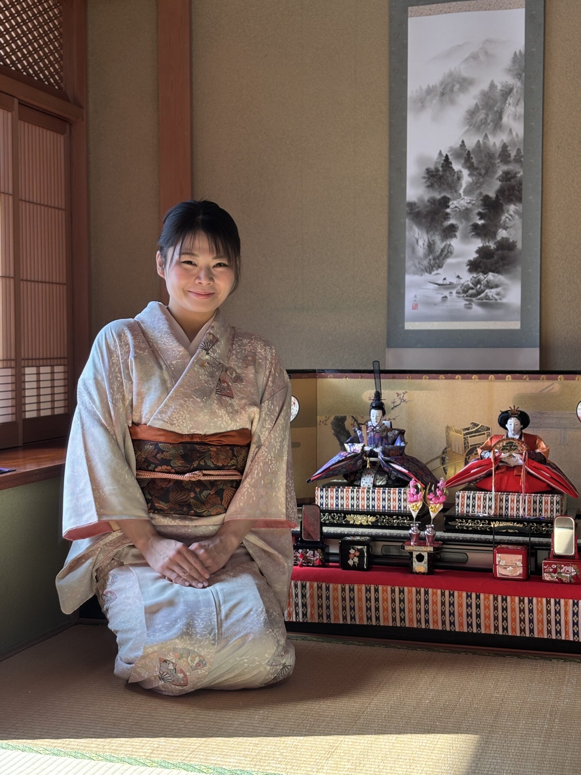 A photo of our guest in Kimono sitting by the Hina-Dolls.