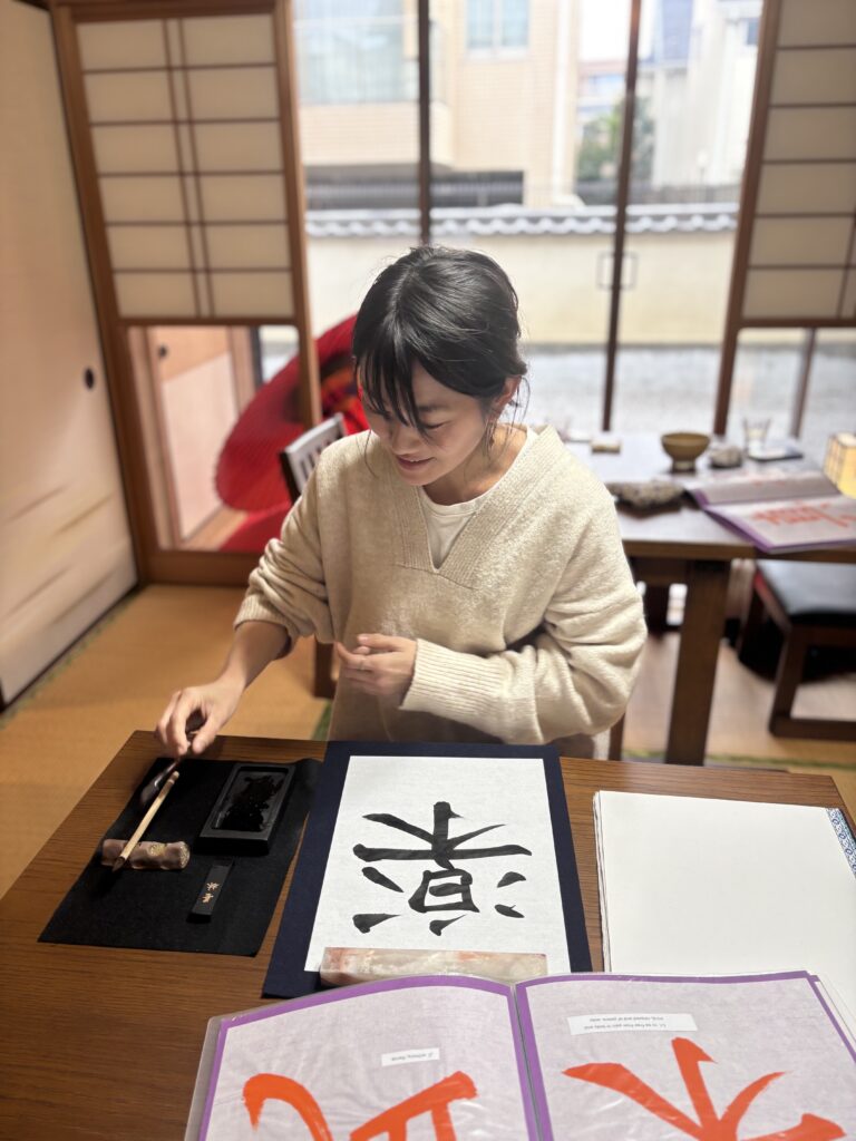 A photo of our guests with her calligraphy work.