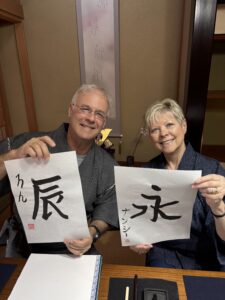 A photo of our guests showing their calligraphy pieces.