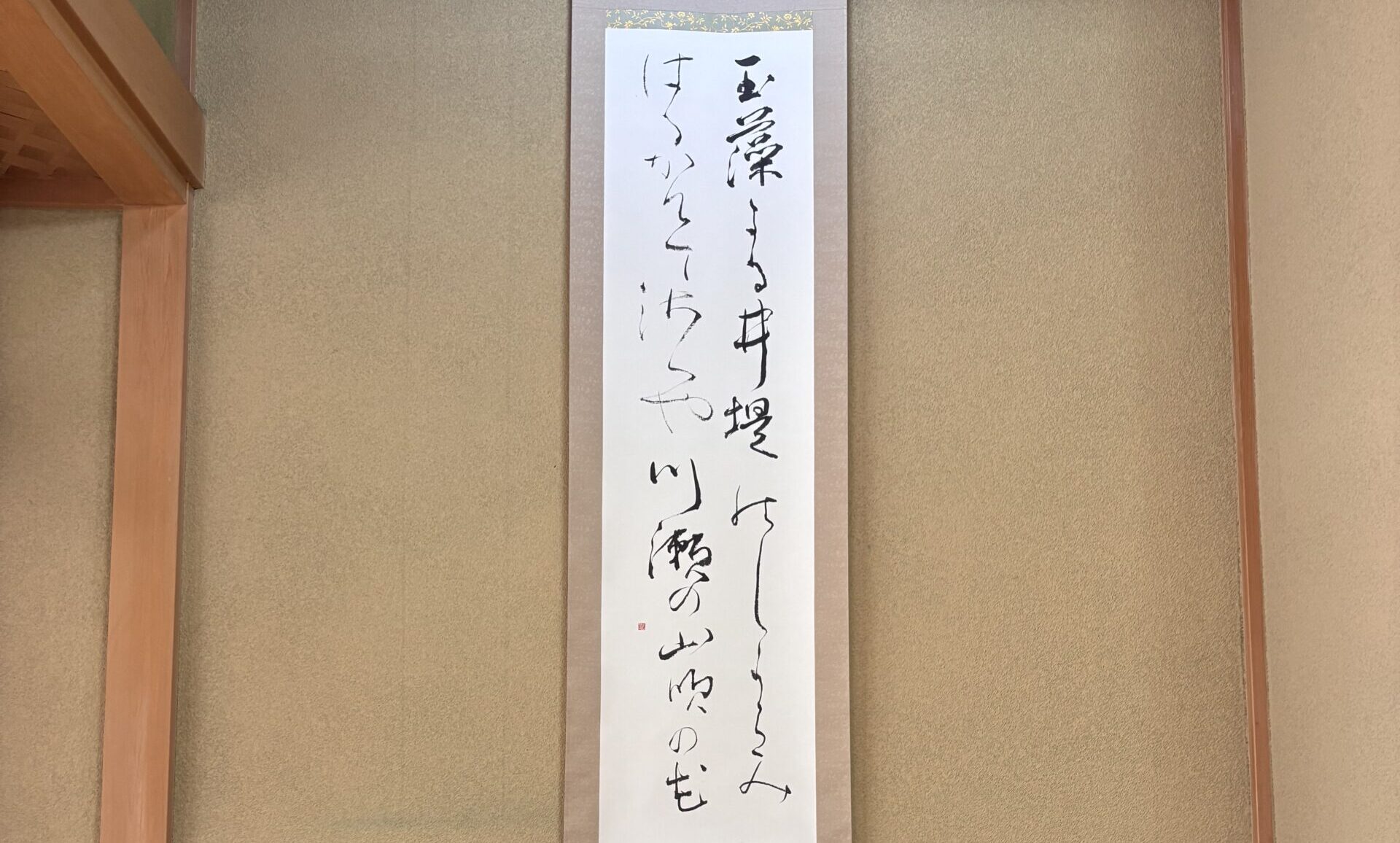 A photo of a hanging scroll displayed in a tokonoma alcove.