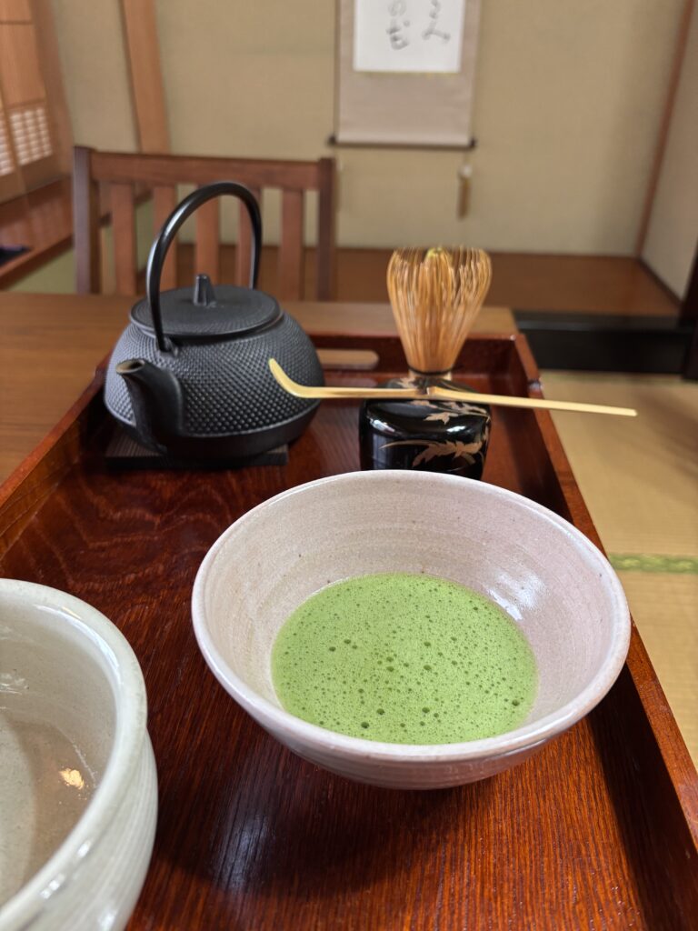 A photo of a cup of matcha and tea utensils.