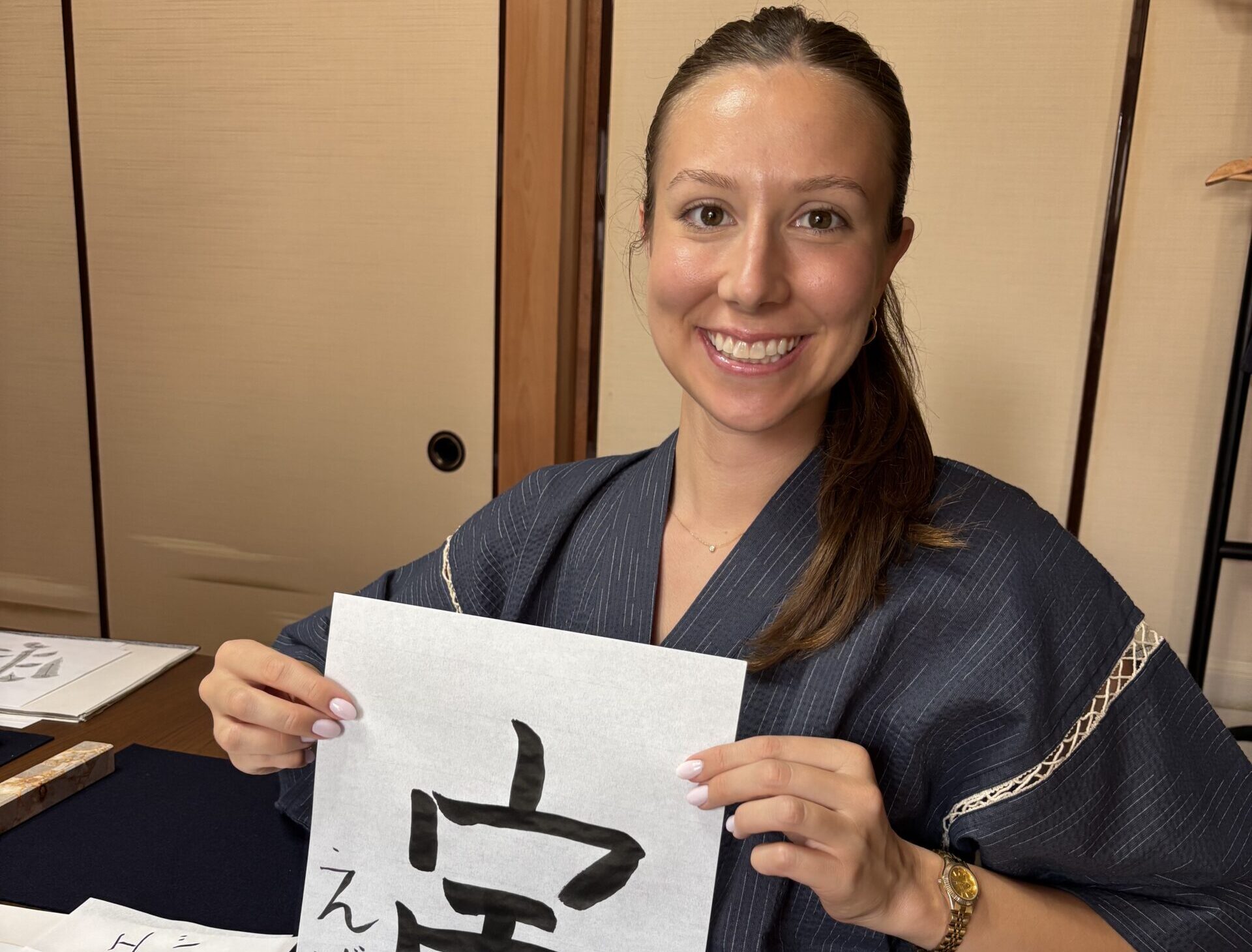 A photo of our guest holding her calligraphy work "Zodiac sign: Tiger".