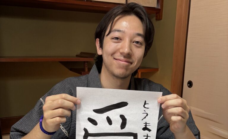 A photo of our guest holding his calligraphy work "love".