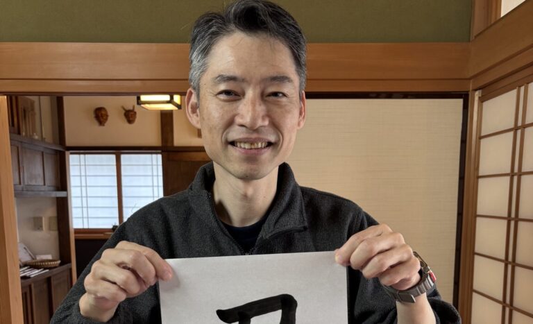 A photo of our guest and his calligraphy work.