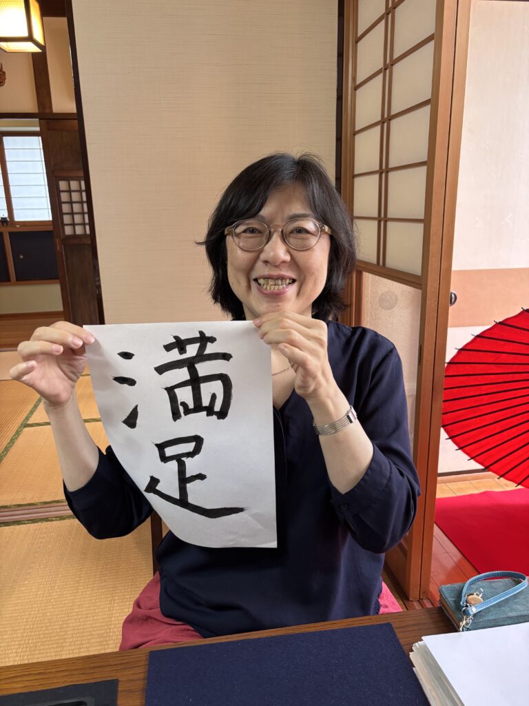 A photo of our guest with her calligraphy work.
