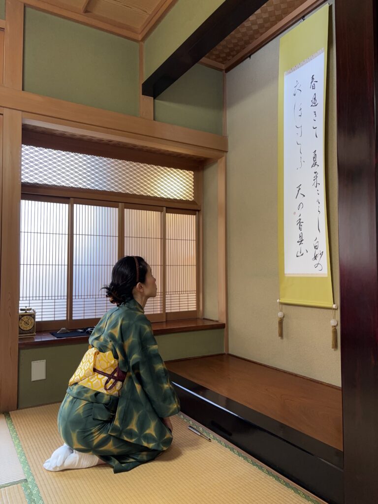 A photo of the manager looking at the hanging scroll.