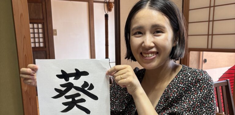 A photo of our guest with her calligraphy work.