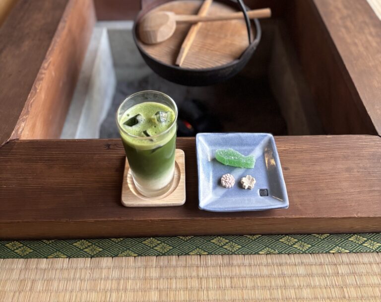 A Photo of iced matcha latte and sweets by the irori hearth.