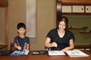 A photo of our guests (mother and child) experiencing calligraphy.