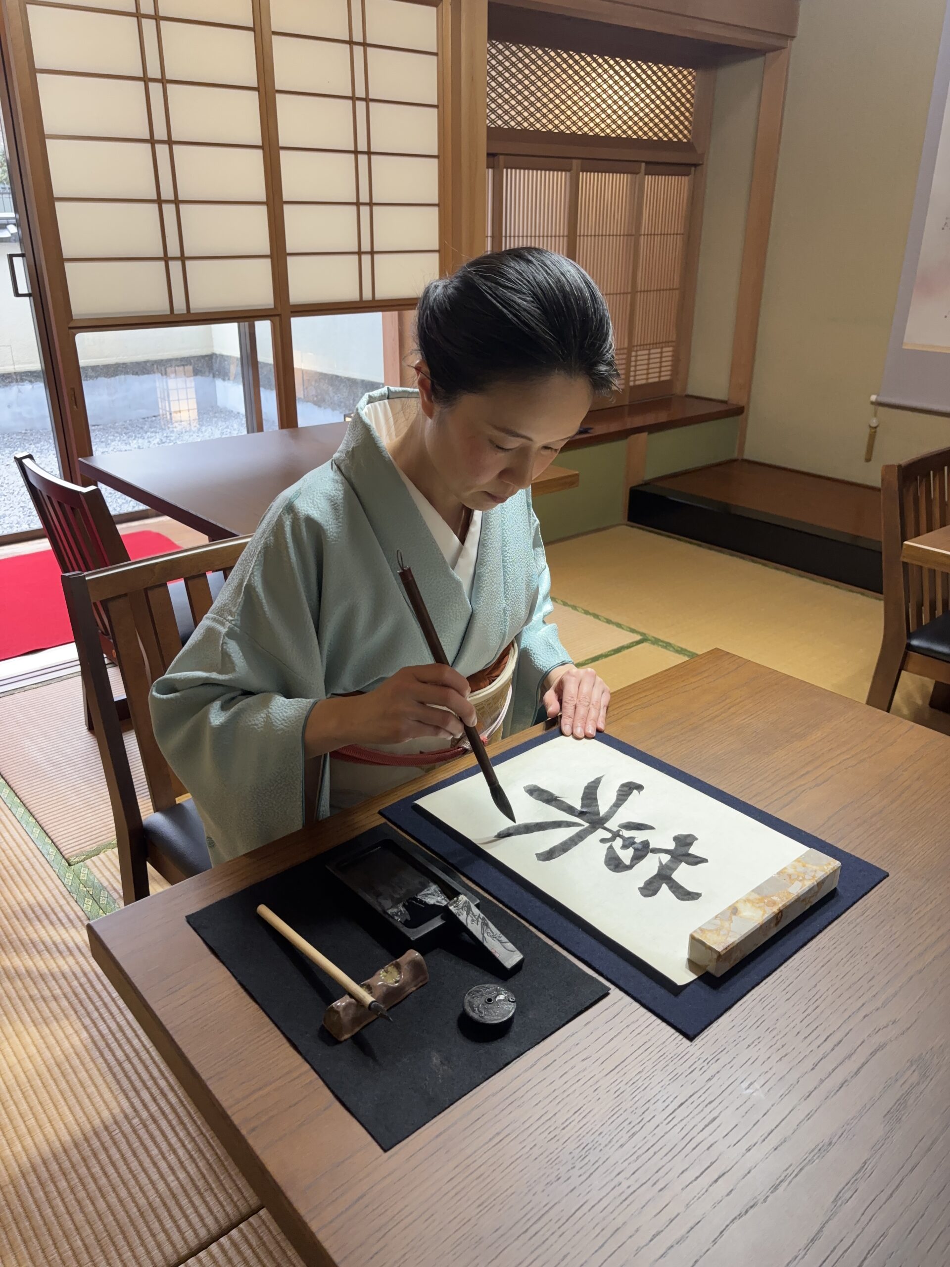 the manager is holding a calligraphy brush